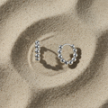 Créoles boules argent flat lay
